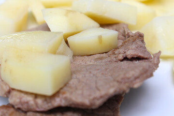 meat with cut potatoes. meat and potatoes with selective focus. meal with boiled potatoes and meat.