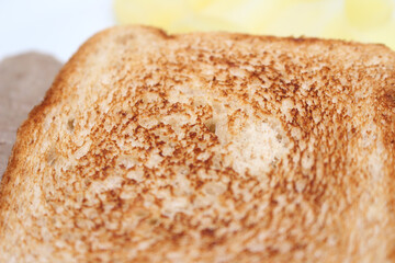 loaf of bread. toasted bread with potatoes and meat blurred in the background. bread texture. toasted bread with selective focus.