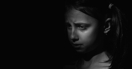 Black and white image of crying young girl. Loneliness, pain, child tragedy. Copy space for text or...