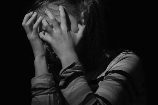 Black and white image of crying young girl. Loneliness, pain, child tragedy. Black and white image.