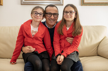 Ritratto di un papa con le figlie gemelle di nove anni.