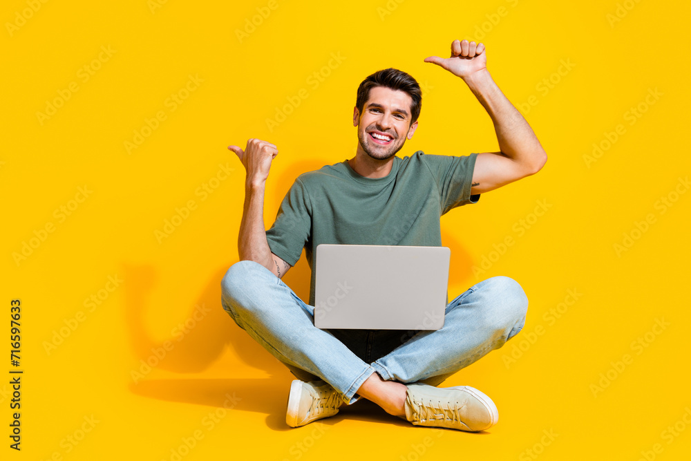 Poster full length photo of cute cheerful man dressed khaki t-shirt texting modern device two thumbs empty 