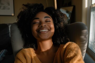 Joyful young African American woman sitting in a chair with a warm smile
