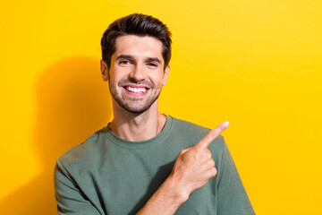 Photo of good mood man with bristle stylish hair dressed khaki t-shirt indicating at offer empty...