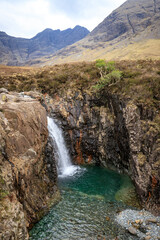 Fototapeta na wymiar Mystical Cascade: A Waterfall in Fairy Pools Amidst Majestic Mountains