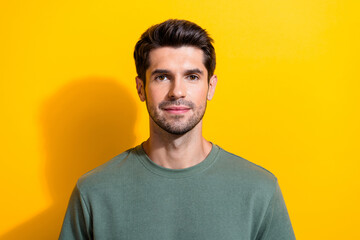 Photo of serious confident man with bristle stylish hairdo dressed khaki t-shirt look at camera...
