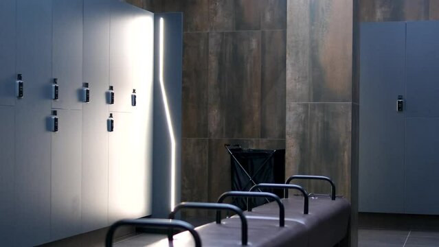camera moves around shows open doors of the closet with tennis equipment. Sports club. Wardrobe. American locker room gym school interior. Office wardrobe, locker room in sport club. Dressing room
