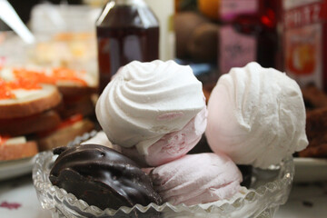 Marshmallows in a plate against the background of food. Stock photo of dessert.