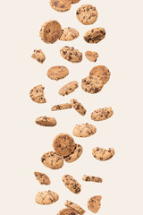 Fototapeta na wymiar Chocolate biscuits levitating on a cream backgound. Sweet food concept.