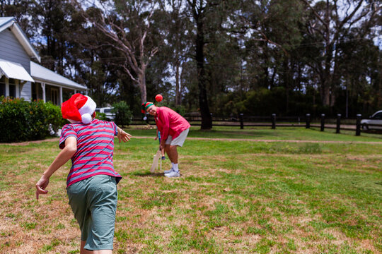 Christmastime family fun with granddad up for batting in backyard cricket game