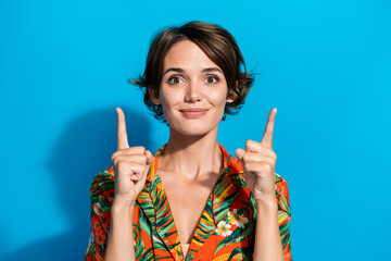 Portrait of gorgeous friendly girl indicate fingers up empty space proposition ad isolated on blue...