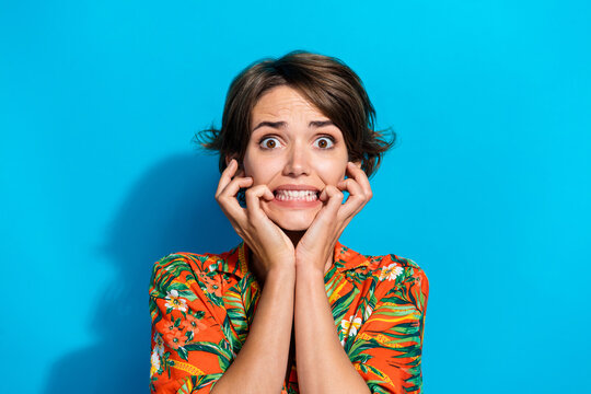 Photo of terrified embarrassed girl wear trendy clothes biting fingers celebrating halloween horror fear isolated on blue color background