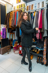 Fototapeta na wymiar Stylish woman looking at clothes in store