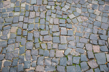 Stone wall with old bricks in the city. Gray stone block surface.