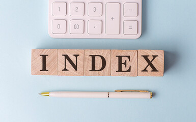 INDEX on wooden cubes with pen and calculator, financial concept