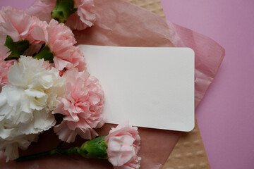 Beautiful pastel color carnation flowers composition with blank letter paper on pink and craft paper. Flower composition image for Mother's day, Women's day and anniversary design.