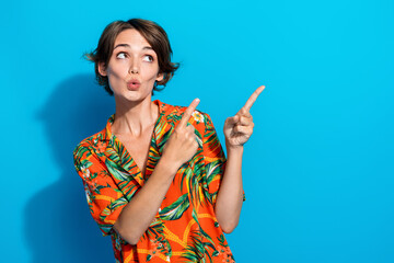 Photo of surprised lovely girl wear trendy clothes presenting empty space recommend buy novelty isolated on blue color background