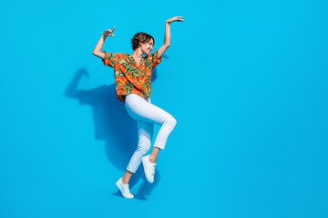 Full length profile portrait of positive lovely person raise arms dancing empty space isolated on blue color background - obrazy, fototapety, plakaty
