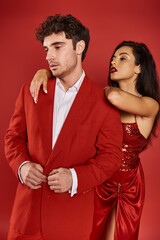 alluring young woman with red lips leaning on shoulder of good looking man in suit on Valentines day