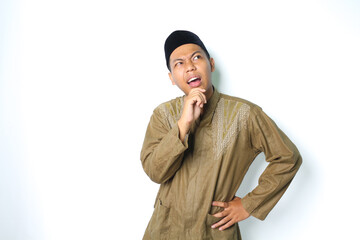 thoughtful asian muslim man thinking seriously with hand on chin wearing koko clothes isolated on white background