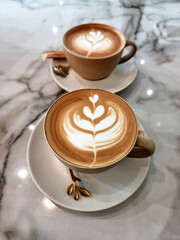 Two cups of hot latte art simple tulip coffee on a table