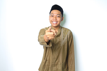 smiling asian muslim man wearing koko clothes pointing at camera with excitement isolated on white...