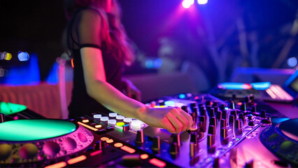 Obraz na płótnie Canvas Close em mão feminina, manuseando os botões do controlador de dj, durante uma festa com muitas luzes coloridas.