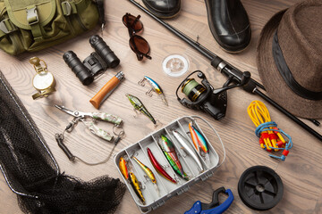 Fishing rod, tackles and other stuff for recreation activity on the wooden desk. Fishing season...