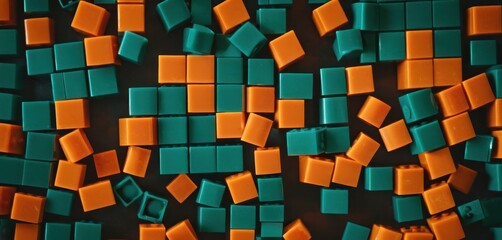  a group of orange and green cubes sitting on top of a black surface with orange and green squares on top of the cubes and bottom of the cubes.