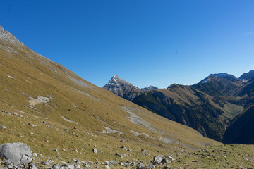 Majestic mountain peak rising above rolling hills under a clear blue sky