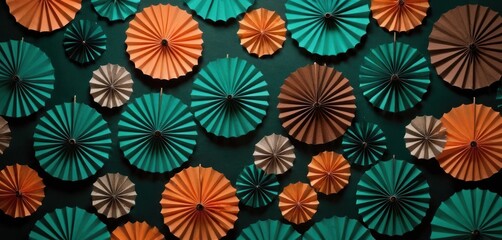  a group of orange and green paper fans hanging on a wall next to a wall of other orange and green paper fans on a green wall behind a green wall.