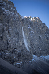 Fototapeta na wymiar A majestic frozen waterfall cascading down a rugged mountain cliff.