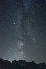 Fototapeta na wymiar Starry night sky above silhouetted mountain peaks.