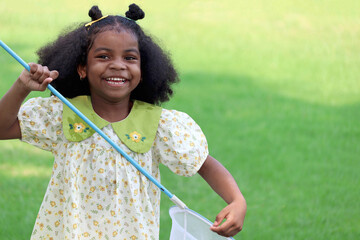 Happy African girl with black curly hair holds scoop-net for catching insect bug and butterfly in...