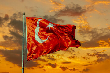 Waving Turkish flag against the background of the sunset sky