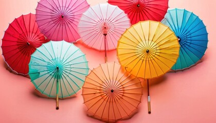  a group of colorful umbrellas sitting next to each other on a pink and pink background with a pink background and a pink background with a few different colors and white umbrellas.
