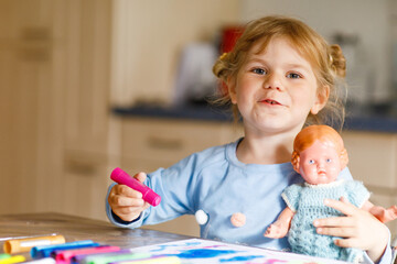 little alone toddler girl painting with felt pens during pandemic coronavirus quarantine disease....