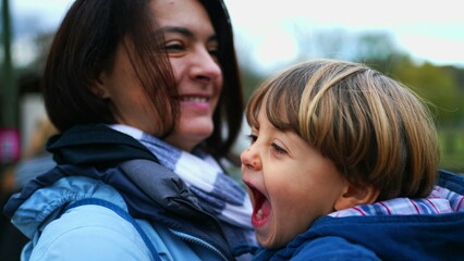 Little boy son kissing mother in the cheek in loving authentic parent and child relationship....