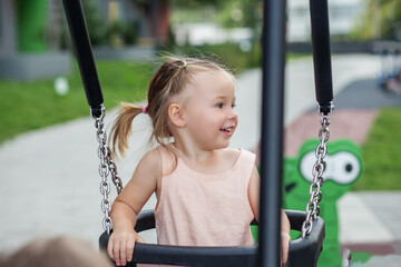 Happy Toddler on a Swing at Sunny Playground