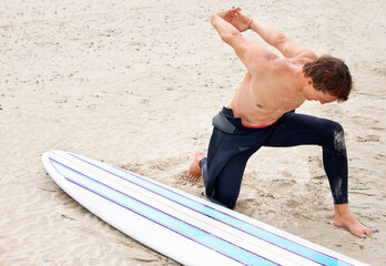 Surfer, man is stretching and beach sand with surfboard for ocean waves and start fitness,...