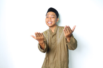 happy asian muslim man wearing koko clothes presenting at camera with open palms isolated on white...