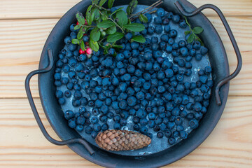 A harvest of blueberries on a wooden background. Forest ripe berry