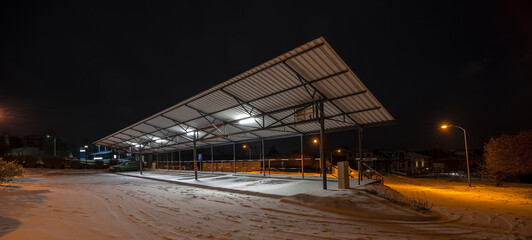 Wiata parkingowa oświetlona panelami słonecznymi - w śnieżną jesienną noc.Miasto (Ostrowiec)...