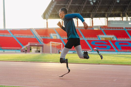 Asian para-athlete runner prosthetic leg on the track alone outside on a stadium track Paralympic running concept.
