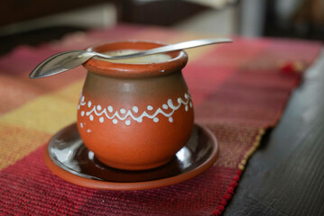 Homemade fermented milk, a popular drink from Serbian cuisine, served in a traditional clay kettle with a spoon on it