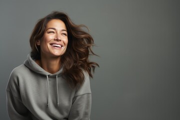 Obraz premium Portrait of a blissful woman in her 30s dressed in a comfy fleece pullover against a soft gray background. AI Generation