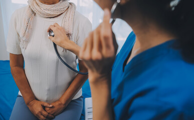 Close up of Female Doctor using stethoscope putting beat heart diagnose with patient in examination room at a hospital, check-up body, Medical and Health Care Concept. - obrazy, fototapety, plakaty