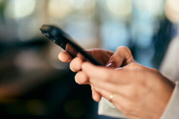 Close-up of a female hands holding and using a mobile phone.