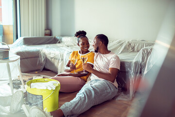 Happy young couple drinking wine after renovating the apartment