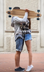 Couple, hiding with skateboard and outdoor in city, hug and excited to learn together and romantic relationship. Cape town, touch and hobby with boyfriend and girlfriend in street, love and dating